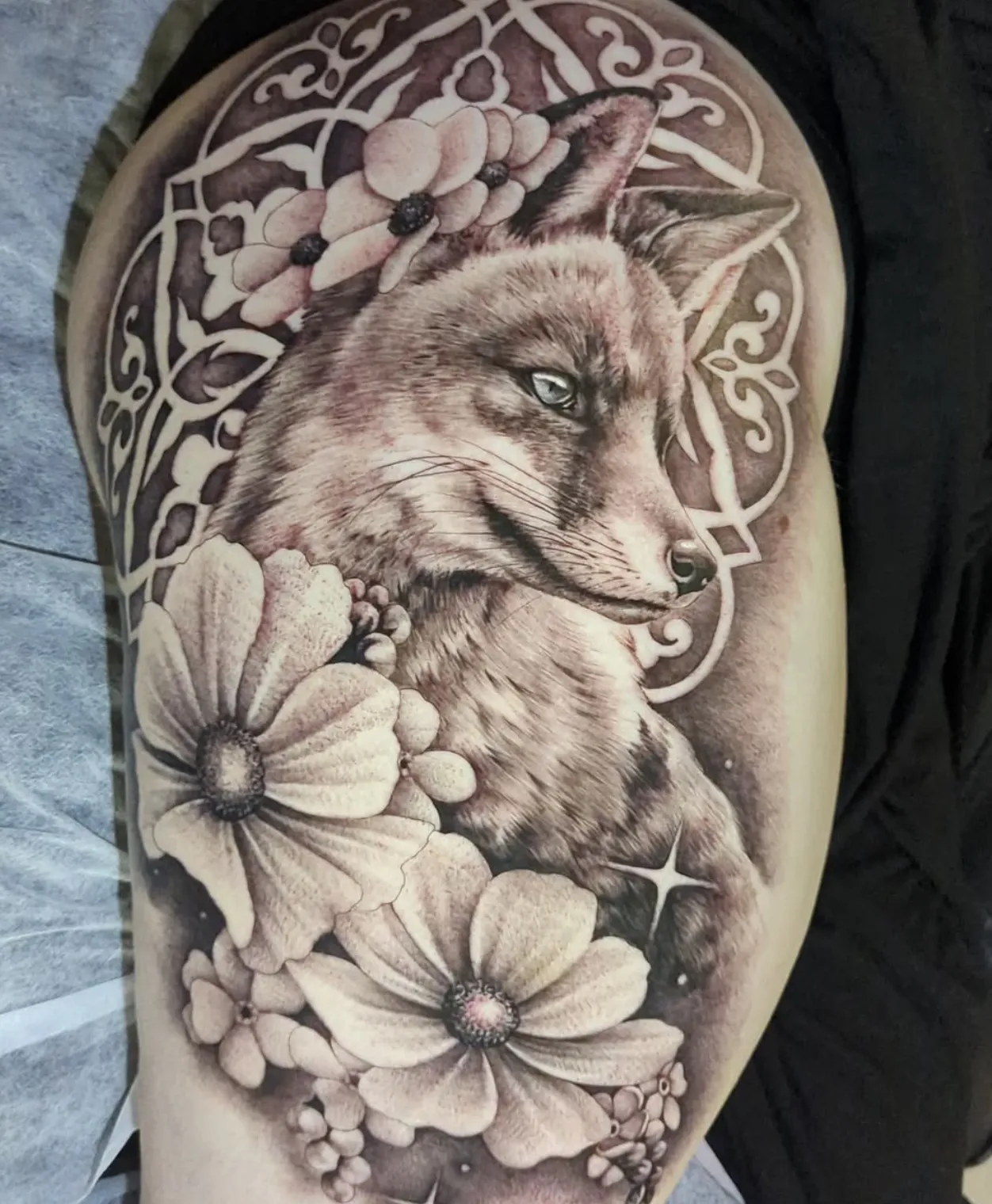Black and grey fox portrait tattoo with floral elements and decorative design